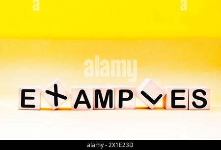 Examples of words written on a wooden block. Examples of text on a yellow background Stock Photo