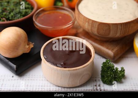 Fresh marinades in bowls and ingredients on white wooden table, closeup Stock Photo