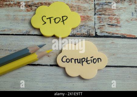 Concept of Stop Corruption write on sticky notes isolated on Wooden Table. Stock Photo