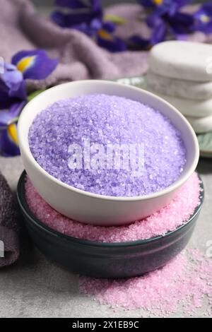 Different types of sea salt and spa stones on grey table, closeup Stock Photo