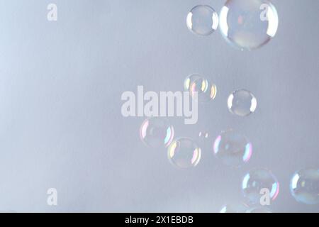 Beautiful transparent soap bubbles on gray background, space for text Stock Photo