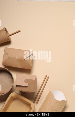 Eco friendly food packaging. Different paper containers on beige background, flat lay. Space for text Stock Photo