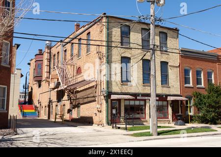 Old storefront and alleyway with staircase painted in rainbow colors.  Woodstock, Illinois, USA. Stock Photo