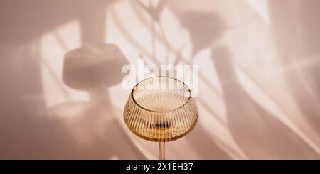 Two glasses with white wine placed on light beige background with shadows Stock Photo