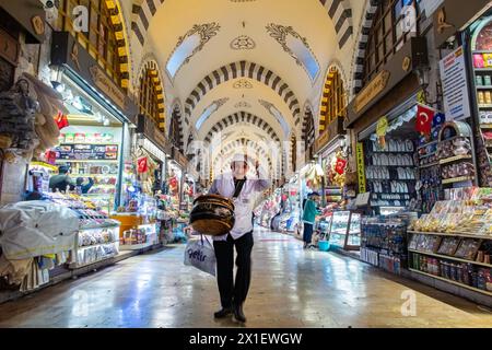 A friendly tea seller doffs his hat in the interior of the Egyptian covered market, famous for spices in Istanbul, Turkey Stock Photo