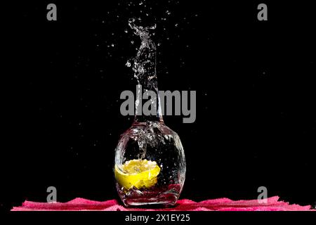 Closeup Image Of Falling Lime Into Clear Water. Splashing Water Outside, Dark Background Stock Photo