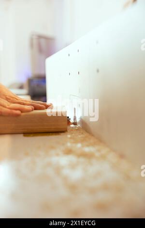 Man using edge jointer in carpenter studio for precision cutting of wood block, making wooden objects, close up shot. Focus on router planer used in woodworking by carpenter for smoothing out panels Stock Photo