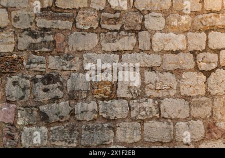 Stone texture of a wall in Montenegro. An ancient wall made of brown coloured stones. Background. Template. For design. Horizontal. Stock Photo