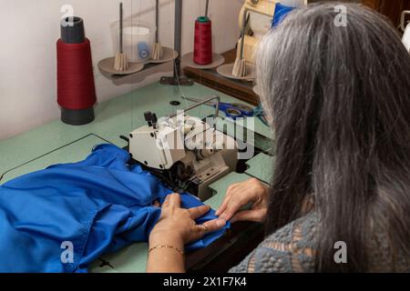 Latin American seamstress working in her sewing workshop with her sewing machine Stock Photo