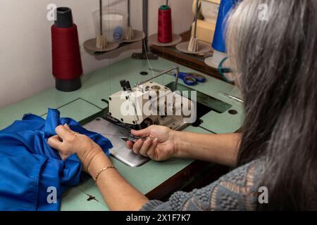 Latin American seamstress working in her sewing workshop with her sewing machine Stock Photo