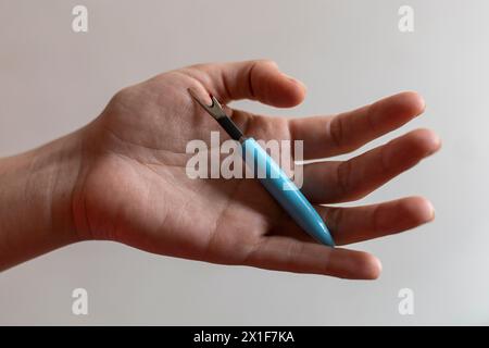 Hands of seamstress holding sewing tool for fraying. Stock Photo