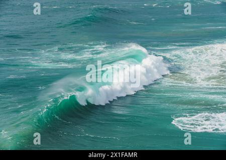 Perfect arc of a wave at Nazare captures the formidable power of the sea. Stock Photo