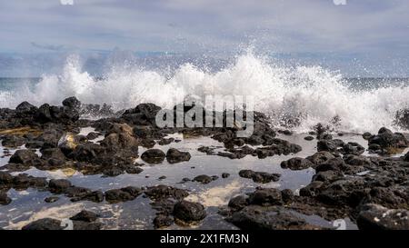 Rough waves from the Pacific Ocean crash against the rocky shoreline of a beach in Lahaina, Hawaii, USA Stock Photo
