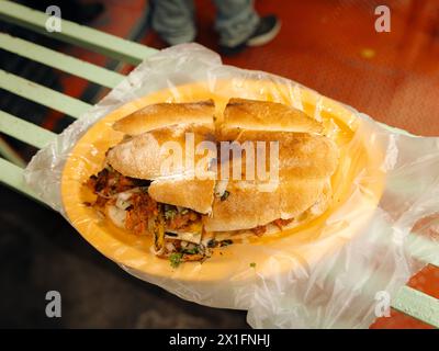 Top view of a Mexican al pastor street torta with cilantro, onion, and pineapple. Stock Photo