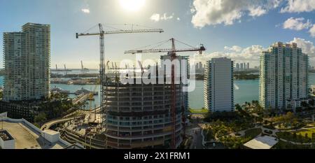 Aerial view of new developing residense in american urban area. Tower cranes at industrial construction site in Miami, Florida. Concept of housing gro Stock Photo