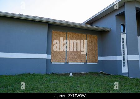 Plywood mounted as storm shutters for hurricane protection of house windows. Protective measures before natural disaster in Florida Stock Photo