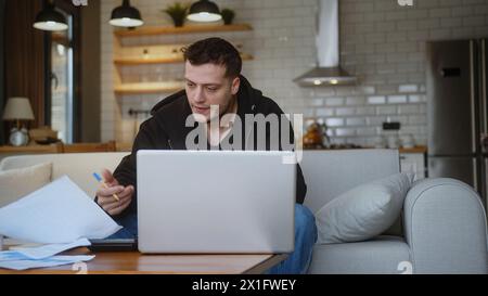 Depressed man feeling worried about financial problem doing paperwork, work on laptop. Stressed entrepreneur looking frustrated thinking of money debt Stock Photo
