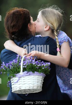 Steinbrunn, Austria - feature: Mother's Day, a celebration honoring mothers and celebrating motherhood, maternal bonds and the influence of mothers in society. PICTURE: 8 year old Sophie hugs her mother on 9th May 2012. - 20120510 PD0269 - Rechteinfo: Rights Managed (RM) Stock Photo