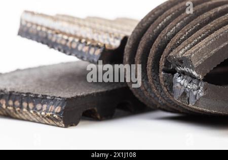 Torn timing belt and generator rivulet belt on a white background. Broken belts in the car, industry Stock Photo