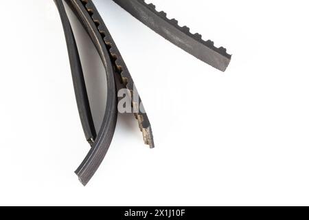 Torn timing belt and generator rivulet belt on a white background. Broken belts in the car, industry. Copy space for text, mechanical Stock Photo