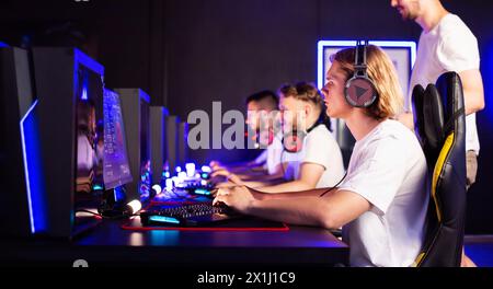 Cyber sport tournament at computer club E-sport championship. Fingers press keys on gaming keyboard close up. Left-handed team gamer plays video game Stock Photo