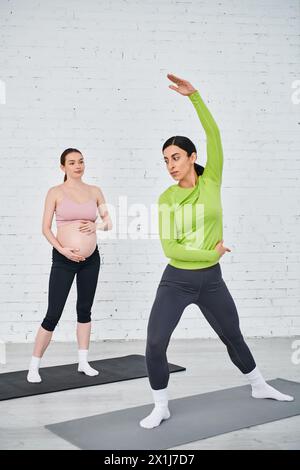 Two pregnant women engaged in a calming yoga session led by an instructor during a prenatal course. Stock Photo