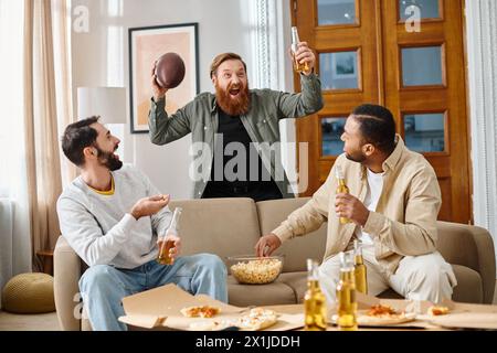 Three cheerful, handsome men of different ethnicities lounging on a couch at home, enjoying each others company in casual attire. Stock Photo