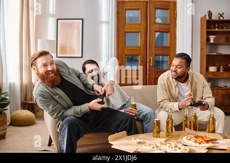 Three cheerful men of different ethnicities sit around a table, laughing and enjoying pizza and beer in a casual home setting. Stock Photo