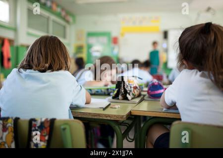back child listening to the teacher's explanation in class Stock Photo