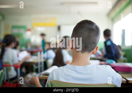 back child listening to the teacher's explanation in class Stock Photo