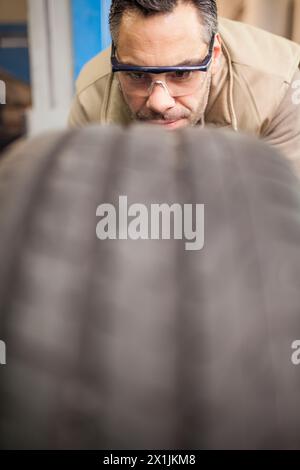 mechanic checks drawing of car wheel in mechanical workshop Stock Photo