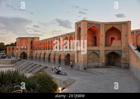 View of the illuminated 17th century Khaju Bridge on Zayanderud river during dry season with dry river bed. Isfahan, Iran. Stock Photo