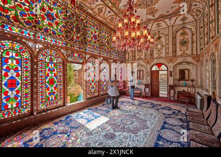 Ornate interior of the reception hall (shahneshin) with large colorful stained glass windows in the Mollabashi Historical House in Isfahan, Iran. Stock Photo