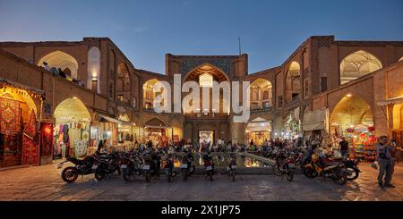 Motorbikes parked at the illuminated Qeysarie Gate, the main gateway to the Grand Bazaar of Isfahan in Naqsh-e Jahan Square. Isfahan, Iran. Stock Photo