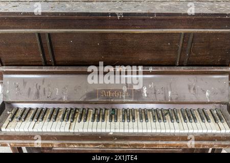 An old abandoned Athelstan upright piano found in a derelict building, London, UK Stock Photo