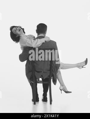 Monochrome image of happy smiling beautiful woman sitting on man and laughing. Happy couple, relationship Stock Photo