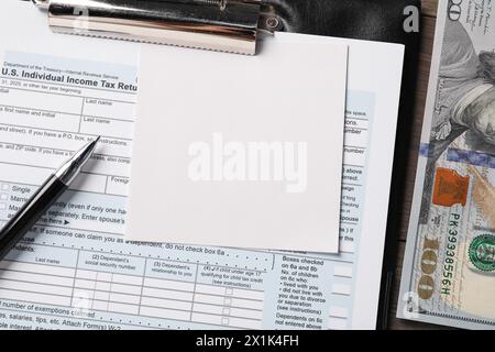 Tax return form, paper note, dollar banknotes and pen on table, top view Stock Photo