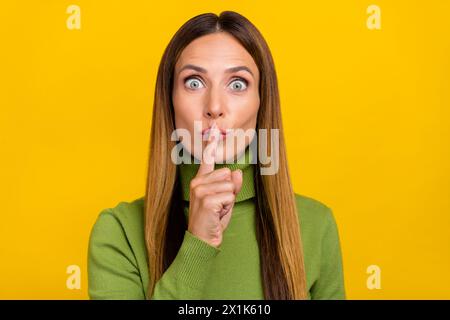 Portrait of pretty lady finger covering close lips do not tell look camera isolated on yellow color background Stock Photo