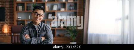 Smiling chinese man in glasses with crossed arms on chest Stock Photo