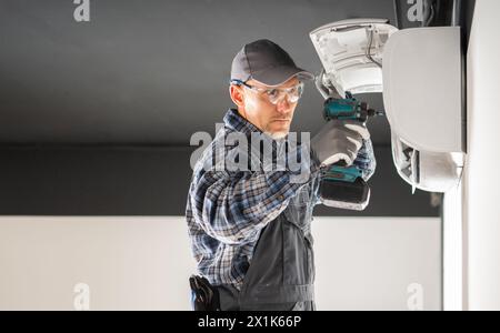 Professional HVAC Technician Performing Air Conditioning Splitter Unit Repair Stock Photo