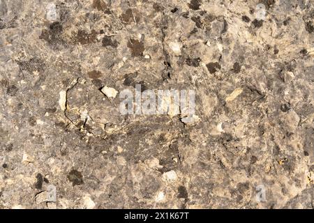 Texture of big rough limestone, with stone chippings lying on it, and cracks where the stone was broken. Stock Photo