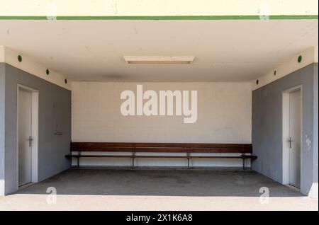 Solid bus shelter made of concrete, with a big bench at one wall. Stock Photo