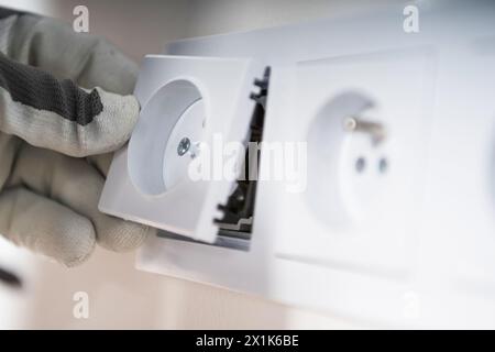 European System Power Outlets Installation Close Up. Electrician at Work. Stock Photo
