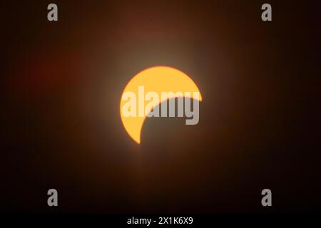 Partial Solar Eclipse with Sun's Crescent in Warm Skies Stock Photo