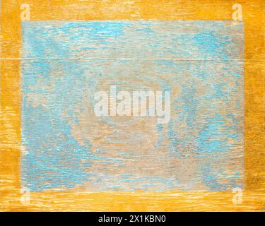 Worn blue paint on old wood plank with gold edge frame. Shabby plank with cracks and stains Stock Photo