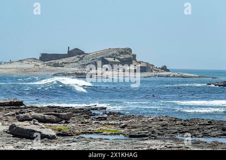 Deserted guano factory and cottages on the beach on Halifax Island over the sound from Diaz Point, Luderitz. Stock Photo