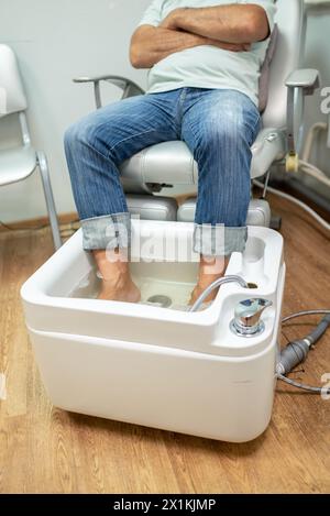 concept of male pedicure, foot pedicure, cosmetologist makes classic pedicure for an elderly male client. Stock Photo