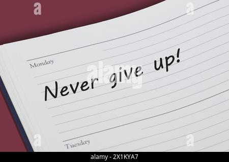 Never give up reminder message in an open diary Stock Photo