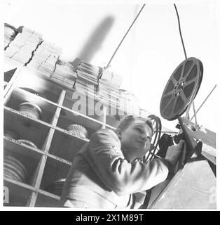 Corporal Duckett, an ATS film projectionist, threads film through a ...
