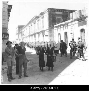 Italian prisoners, escorted by British troops, carry their wounded ...